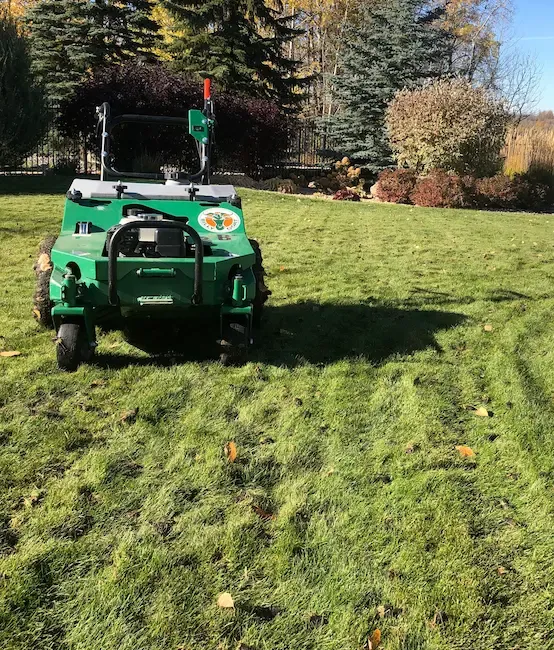 Aerator machine on autumn lawn