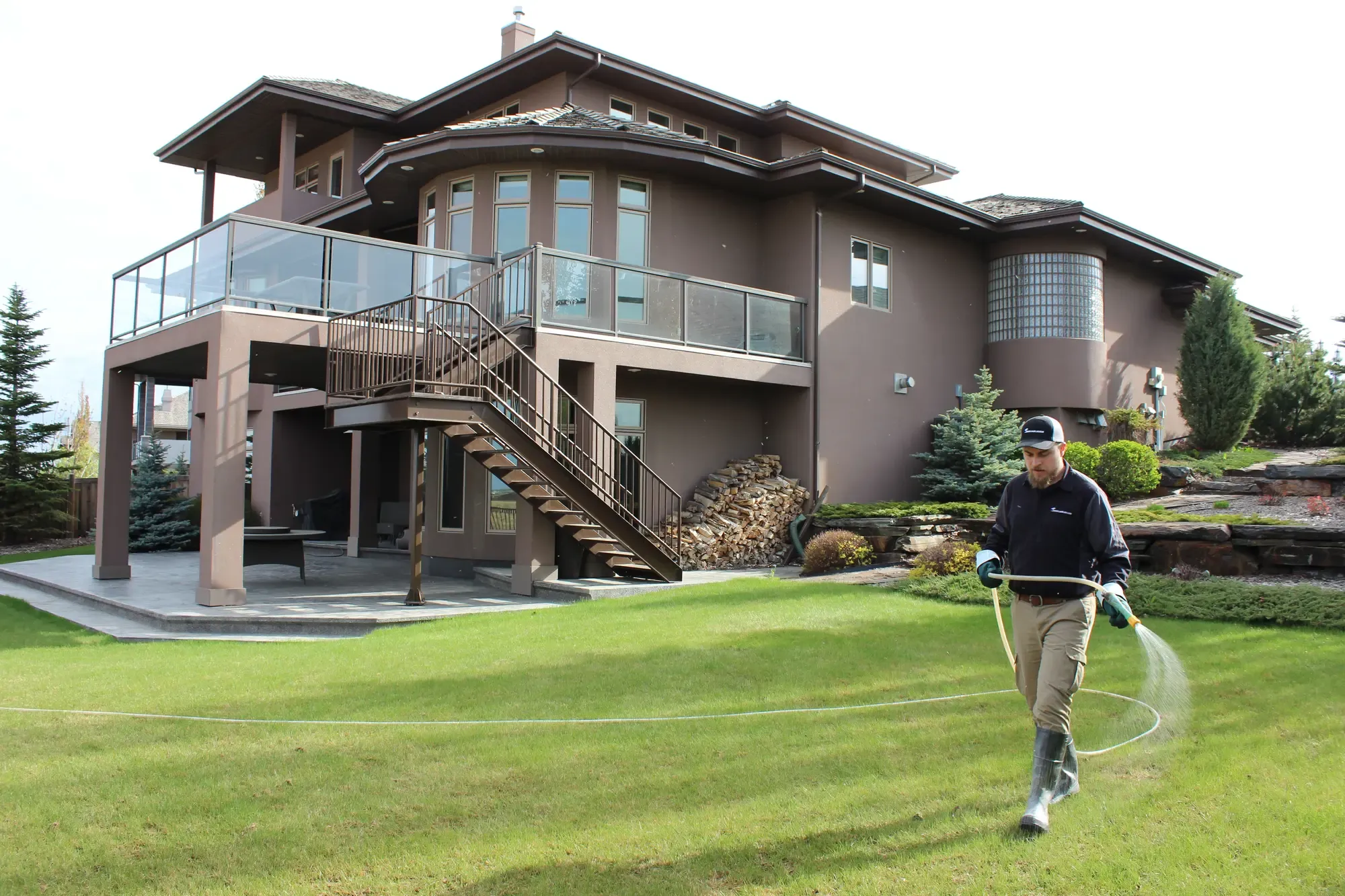 Technician spraying luxury landscaped property